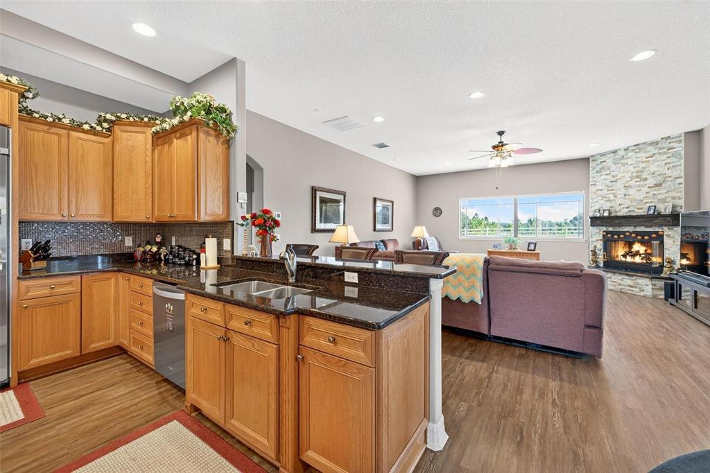 19850 Sugarloaf Mountain Road Clermont, FL 34715 - Photo 37 of 100 a kitchen with stainless steel appliances granite countertop a sink stove and wooden cabinets