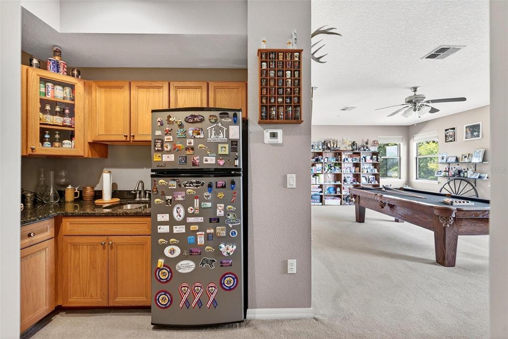 19850 Sugarloaf Mountain Road Clermont, FL 34715 - Photo 66 of 100 a kitchen with stainless steel appliances kitchen island granite countertop a refrigerator and cabinets
