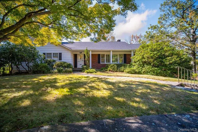 a front view of house with yard and green space