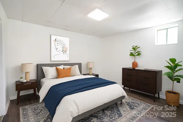 a bedroom with bed lamp and a potted plant