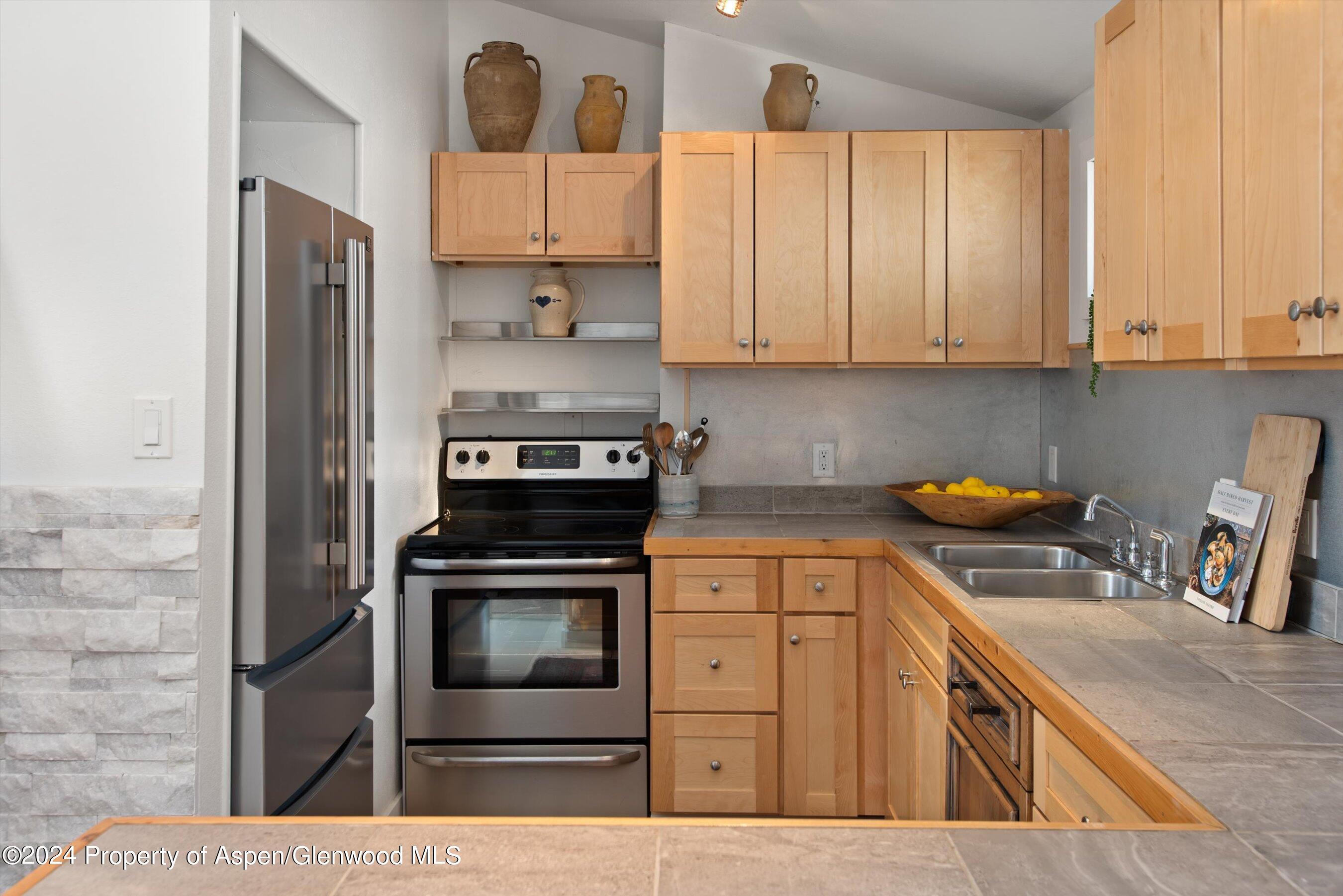 140 Maple Lane Aspen, CO 81611 - Photo 15 of 37 a kitchen with stainless steel appliances granite countertop a stove a sink and a microwave