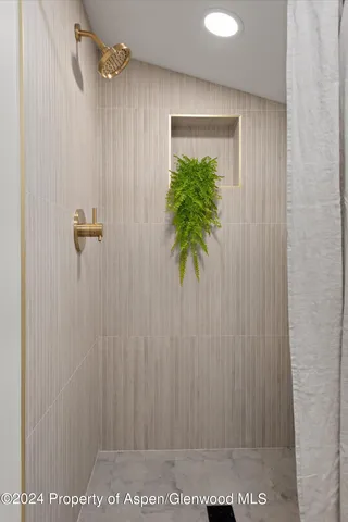 a bathroom with a granite countertop sink a mirror and a shower