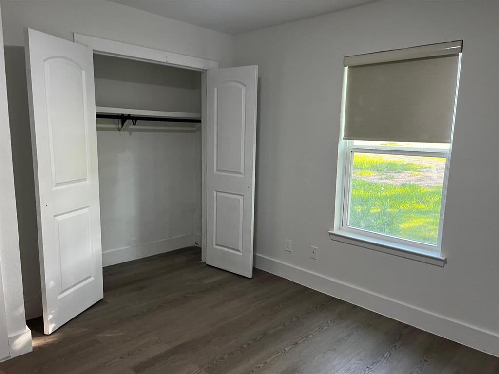 2025 County 1415 Road Bonham, TX 75418 - Photo 9 of 25 Wood-finish flooring, white walls, and a window with a roller shade