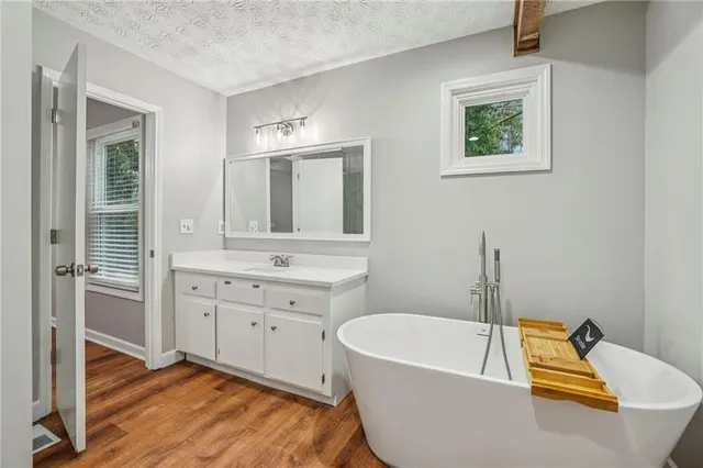 a bathroom with a tub a sink and a window