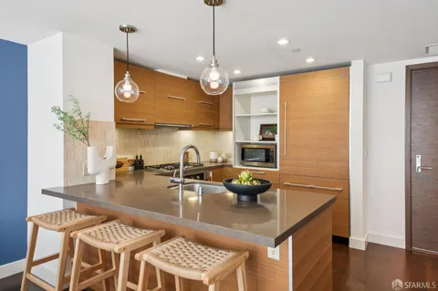 a view of a kitchen area with furniture and wooden floor