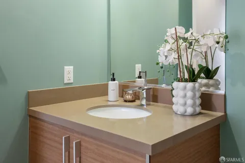 a bathroom with a sink a toilet a mirror a vanity and bathtub