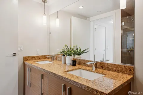 a bathroom with a granite countertop sink and a mirror