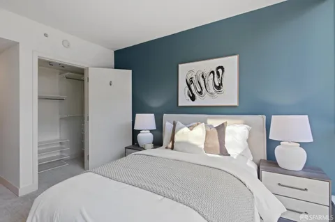 a bedroom with a bed and painting on the wall