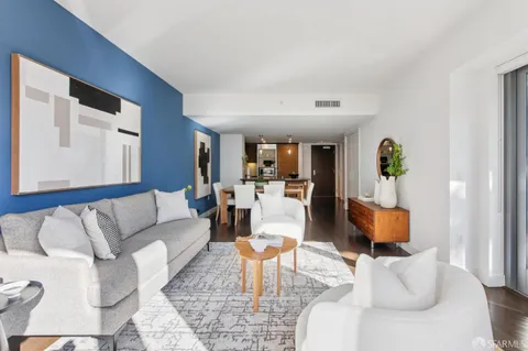 a living room with furniture and a dining table with kitchen view