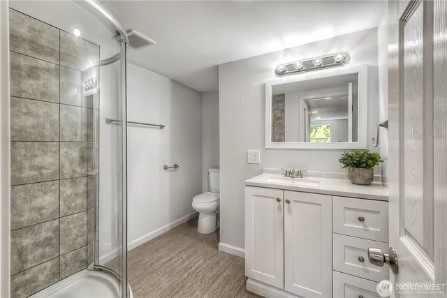 a bathroom with a granite countertop sink a mirror and a shower