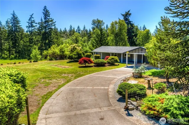 a view of a house with garden and trees