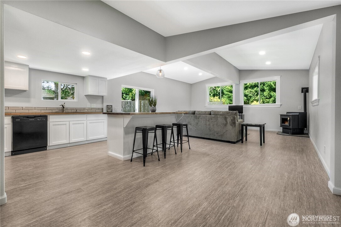 32407 72nd Avenue South Roy, WA 98580 - Photo 4 of 24 a open kitchen with granite countertop a stove top oven a sink a dining table and chairs