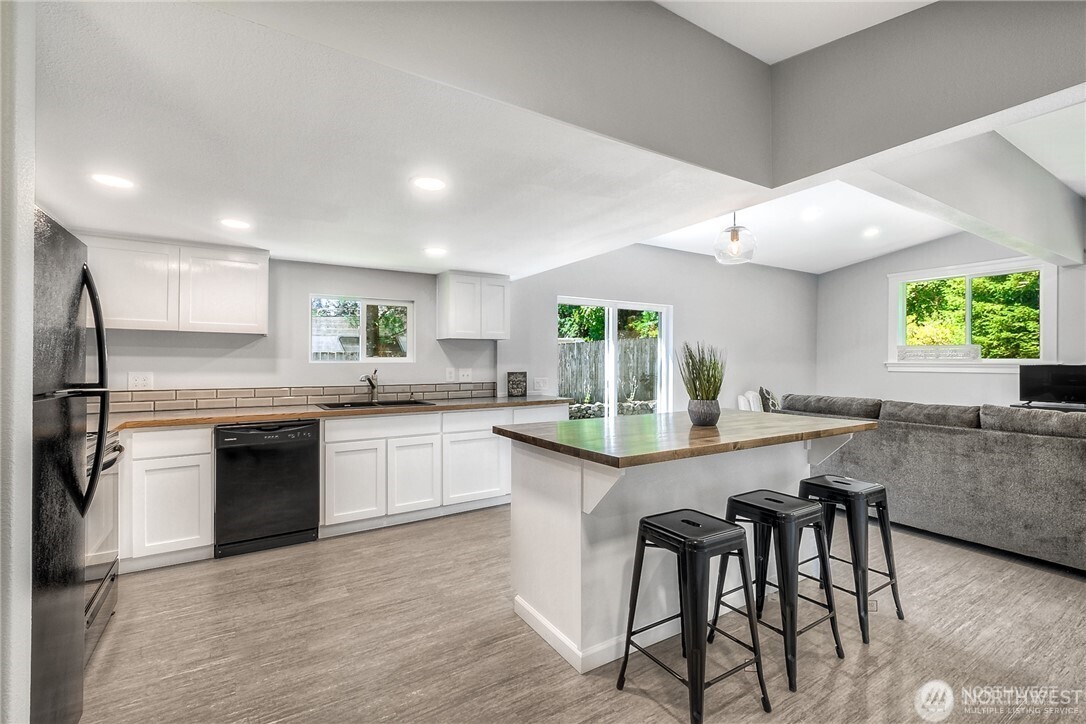 32407 72nd Avenue South Roy, WA 98580 - Photo 5 of 24 a kitchen with granite countertop a table chairs stove a sink dishwasher and cabinets