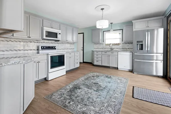 a kitchen with granite countertop a sink cabinets stainless steel appliances and a center island
