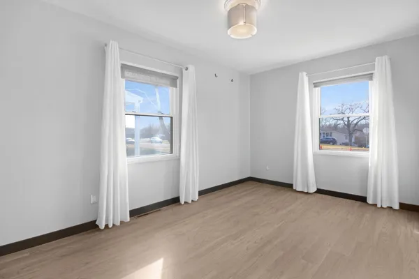 an empty room with windows and closet