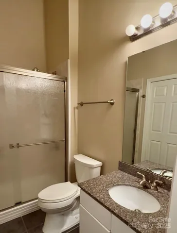 a bathroom with a granite countertop sink toilet and a mirror