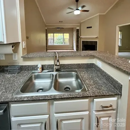a kitchen with granite countertop a sink and a stove