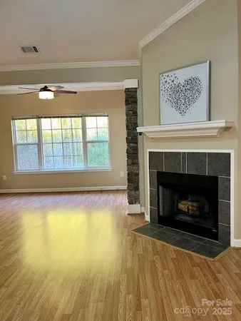 a view of an empty room with a fireplace and a window