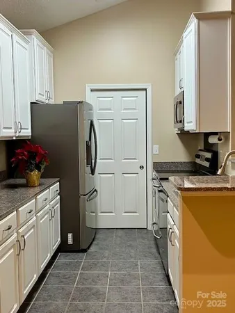 a kitchen with a refrigerator sink and cabinets