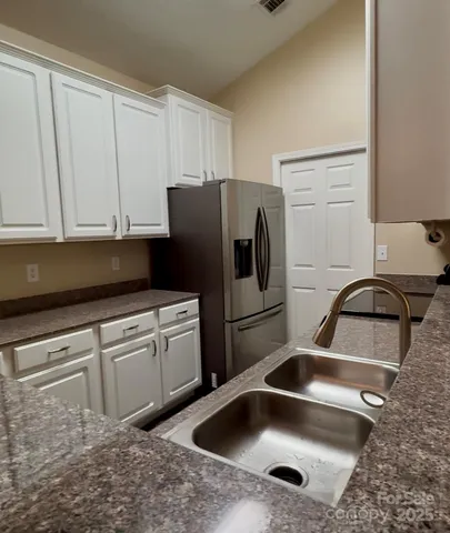 a kitchen with a sink cabinets and refrigerator