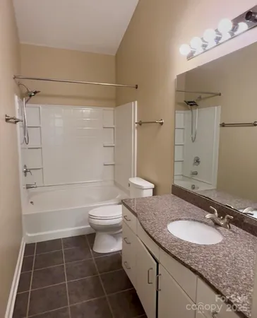 a bathroom with a granite countertop sink toilet a mirror and shower