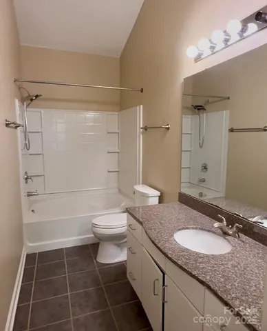 a bathroom with a granite countertop sink toilet a mirror and shower