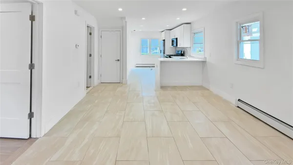 a view of a kitchen with white cabinets and white appliances