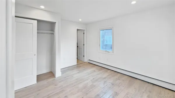 an empty room with wooden floor and closet