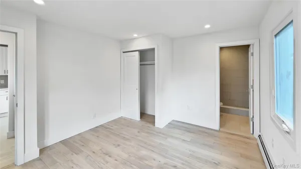 an empty room with wooden floor and closet