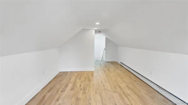 a view of room with wooden floor and white walls