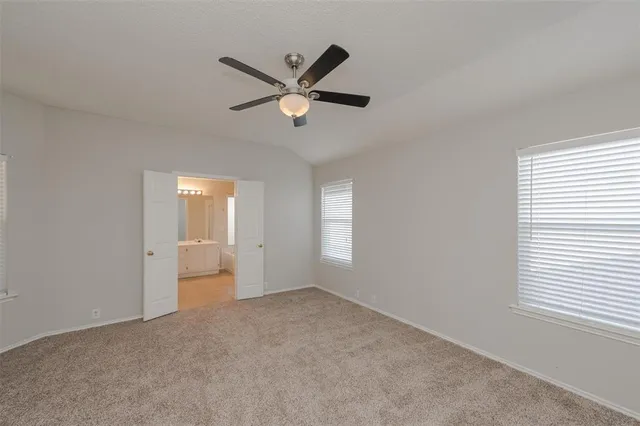 a view of empty room with window and ceiling fan