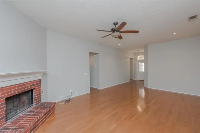 a view of empty room with fireplace and fan