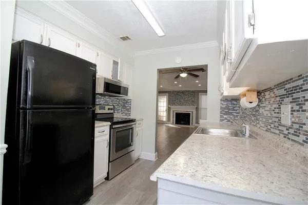 a kitchen with granite countertop a refrigerator stove and oven