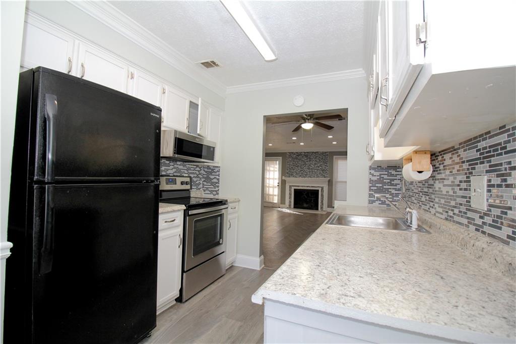 2340 Beaver Ruin Road, Unit UN7 Norcross, GA 30071 - Photo 4 of 20 a kitchen with granite countertop a refrigerator stove and oven