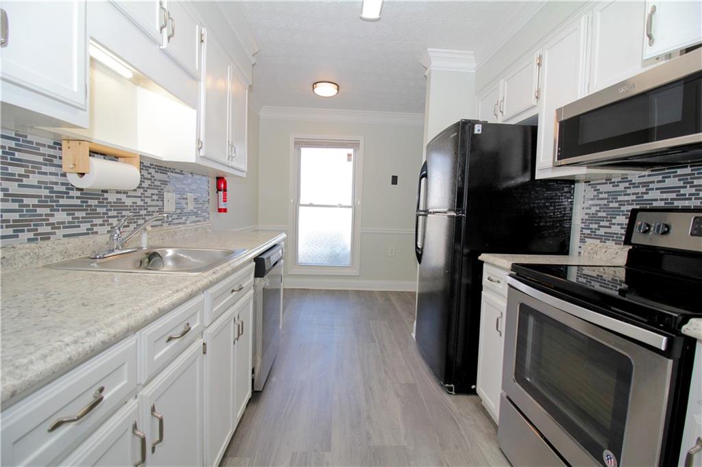 2340 Beaver Ruin Road, Unit UN7 Norcross, GA 30071 - Photo 5 of 20 a kitchen with a sink stove and refrigerator