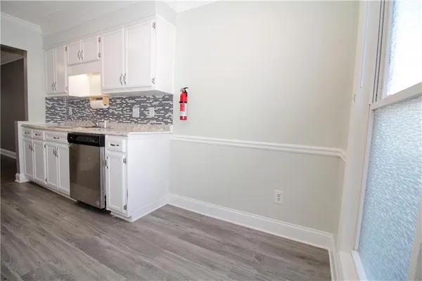 an empty room with wooden floor and cabinets
