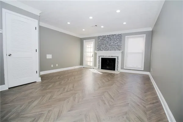 an empty room with fireplace and wooden floor