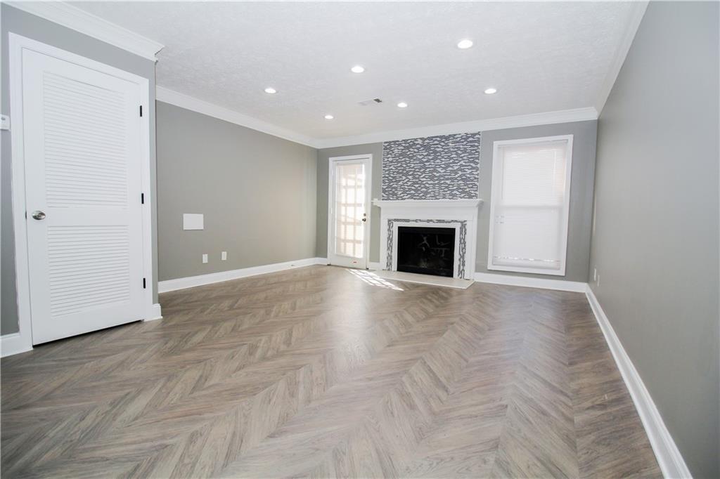 2340 Beaver Ruin Road, Unit UN7 Norcross, GA 30071 - Photo 8 of 20 an empty room with fireplace and wooden floor