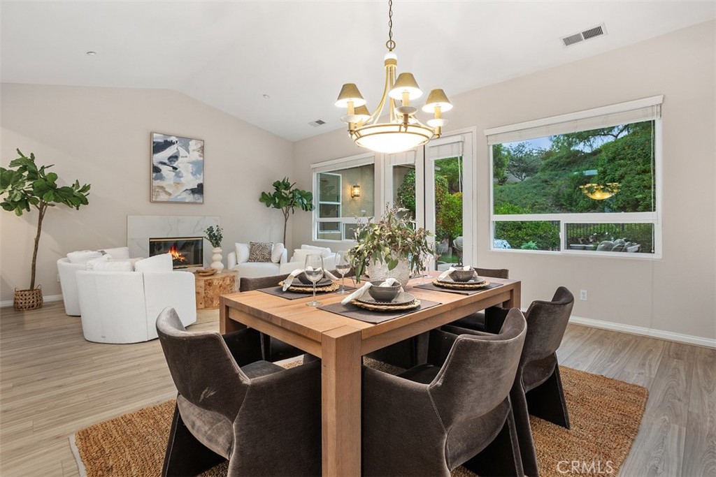 608 Inverlochy Drive Fallbrook, CA 92028 - Photo 12 of 52 a dining room with wooden floor a chandelier a wooden table and chairs