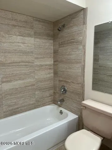 a bathroom with a toilet and a bath tub