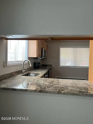 a kitchen with granite countertop a sink window and a counter top space