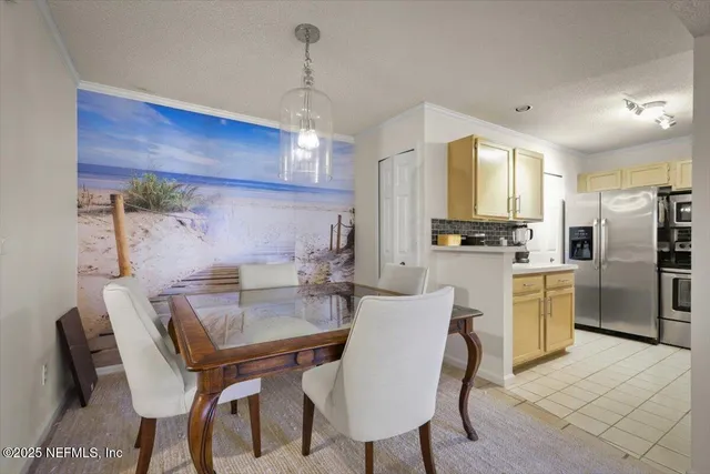 a kitchen with refrigerator a sink and chairs