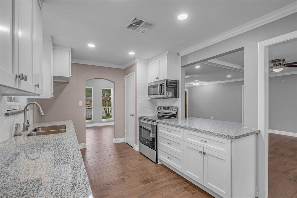 25703 Old Carriage Lane Spring, TX 77373 - Photo 13 of 25 The kitchen features white cabinetry with soft close doors and drawers, granite countertops, and stainless steel appliances, including a microwave and oven