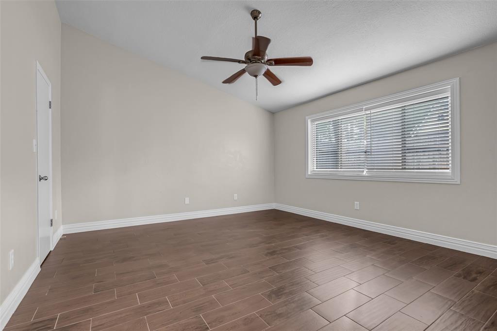 25703 Old Carriage Lane Spring, TX 77373 - Photo 22 of 25 This Primary bedroom features vaulted ceilings, wood-look tile flooring, and large walk-in closet.