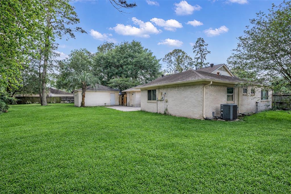 25703 Old Carriage Lane Spring, TX 77373 - Photo 25 of 25 The property features a large grassy yard with mature trees