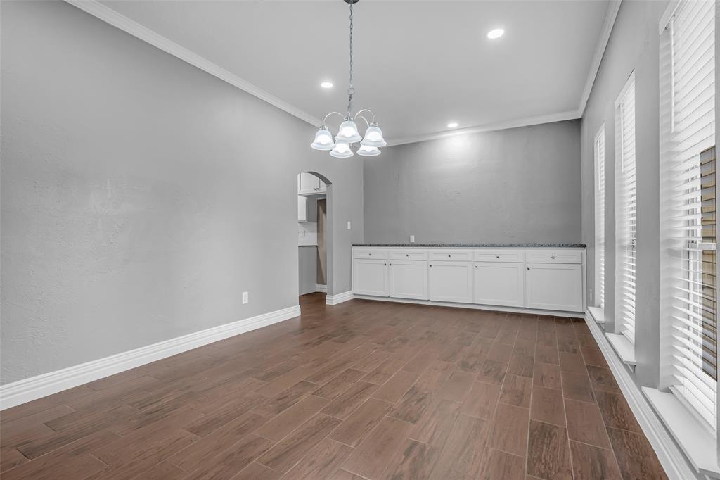 25703 Old Carriage Lane Spring, TX 77373 - Photo 4 of 25 Spacious dining area featuring rich wood-look flooring, a chandelier, and overhead lighting.
