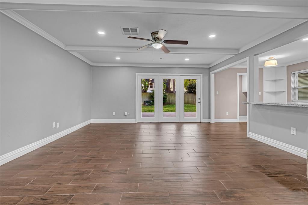 25703 Old Carriage Lane Spring, TX 77373 - Photo 7 of 25 Spacious room featuring wood-look tile flooring, light grey walls, and a ceiling fan with integrated lighting
