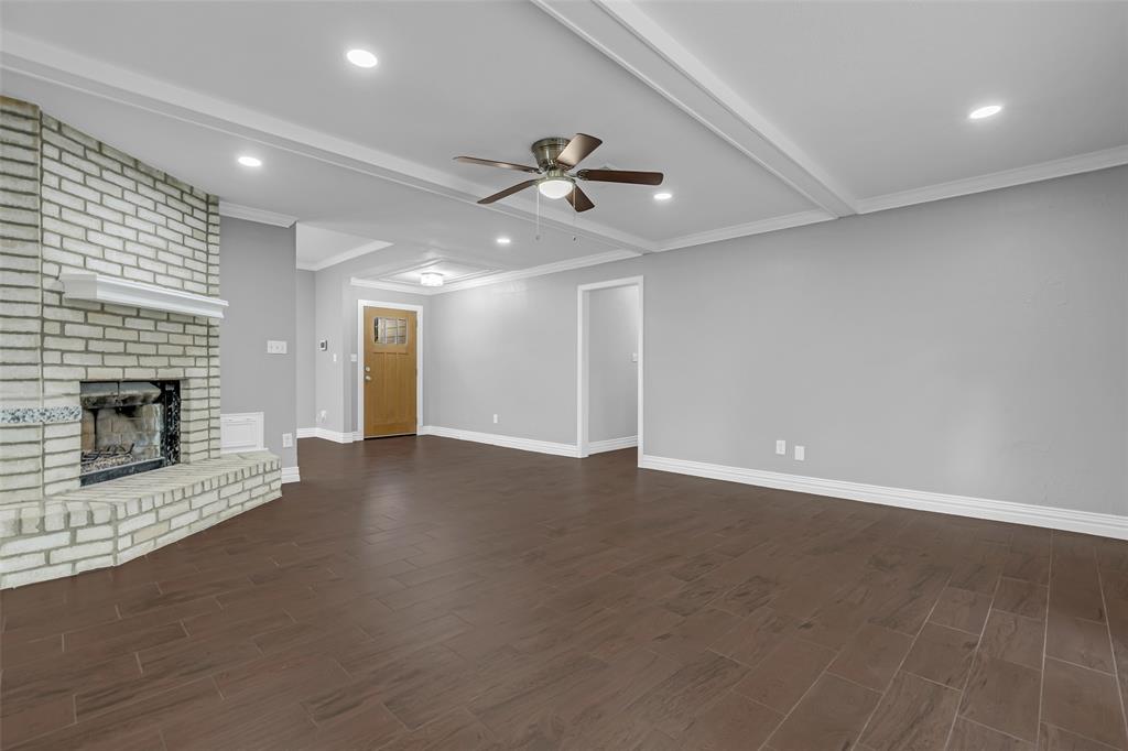25703 Old Carriage Lane Spring, TX 77373 - Photo 8 of 25 The living area features a brick fireplace, dark tile flooring, and a plenty of light.