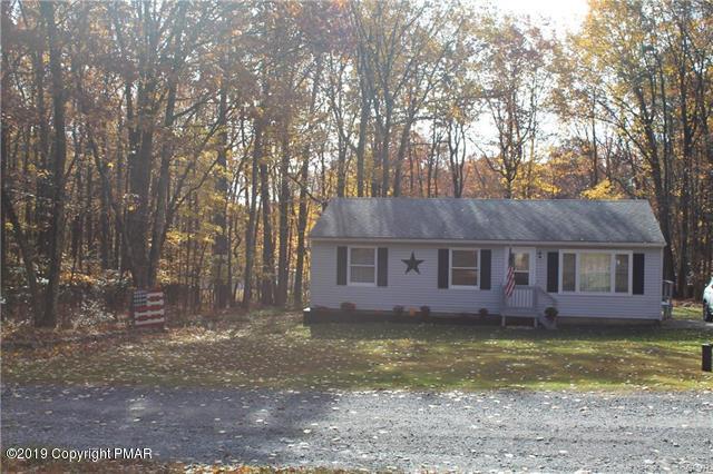 a view of a house with a yard and large tree