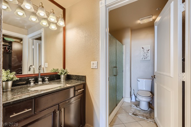 270 East Flamingo Road, Unit 315 Las Vegas, NV 89169 - Photo 6 of 11 A dark wood vanity with a granite countertop and a framed mirror offers a clean, inviting atmosphere.